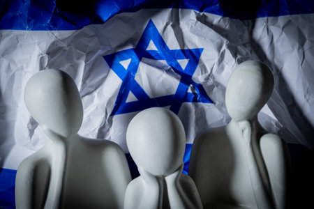 Miniature people with crumpled flag on background. Selective focus. Political concept.の写真素材