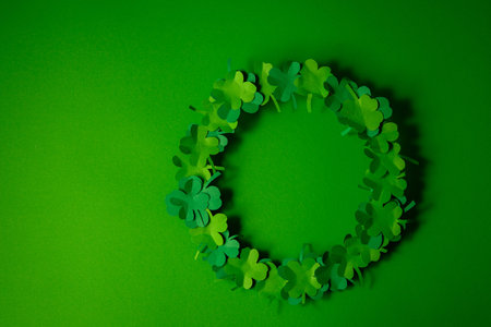Round frame made of green clover leaves on green background. St. Patrick's Day concept