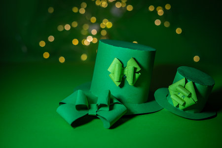 Paper origami leprechaun hats on green background with bokehの写真素材