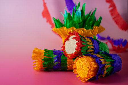 Vibrant handmade paper cactus and a mini piÃ±ata are displayed against a pink and purple background, capturing the festive and colorful spirit of Mexican celebrationsの写真素材