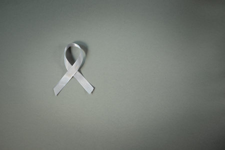 Gray awareness ribbon on gray backgroundの写真素材