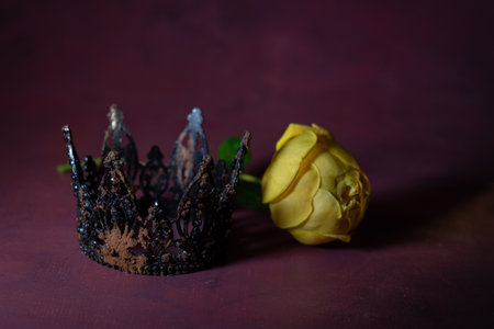 Yellow rose and black crown on dark background. Selective focus.の写真素材