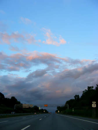 Traveling down the highway under a chaotic sky.の写真素材