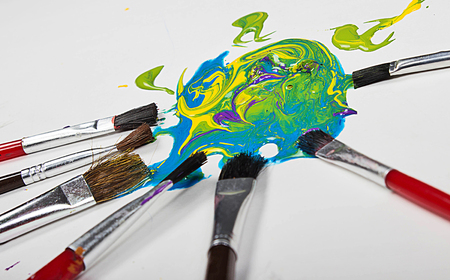 abstract background of paint brushes and splattered paint laying on a white backgroundの写真素材