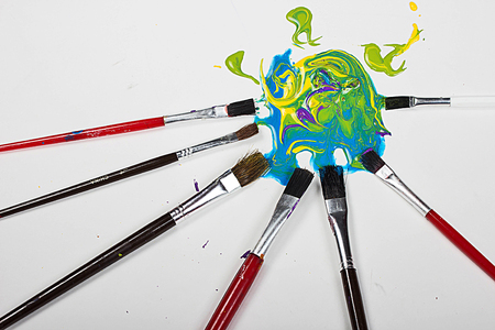 abstract background of paint brushes and splattered paint laying on a white backgroundの写真素材