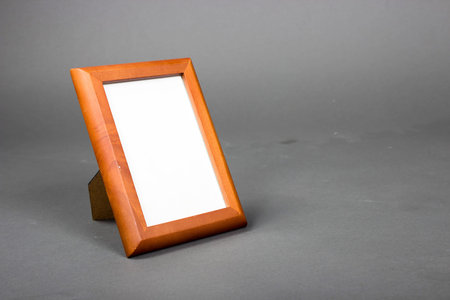 blank wood picture or photo frame standing on a gray background
