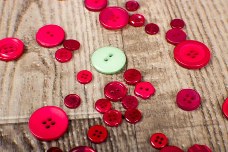 close up detail and texture of red and green buttons on wood grain backgroundの写真素材