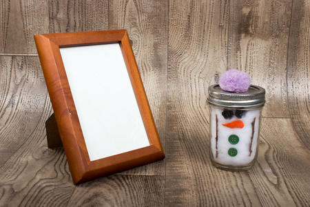 christmas background with a empty wooden picture fram and hand made snowman decorationの写真素材