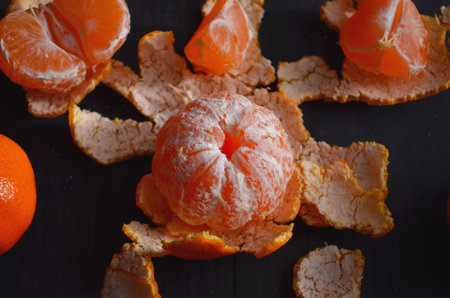 Juicy tangerines and tropical fruits on the New Year's table. On a wooden background.