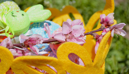 Easter decorative eggs in the grass with flowers and a basket. Easter decoration.