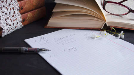 Book and black note with pen. Literature for the holidays and summer. Notes and quotes. Books on the dark table.の写真素材