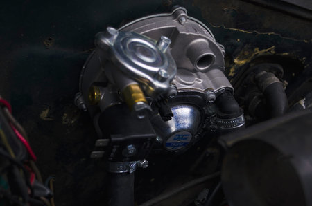 Reducer of a gas installation. Auto mechanic working on a car engine in a mechanics garage. Car...