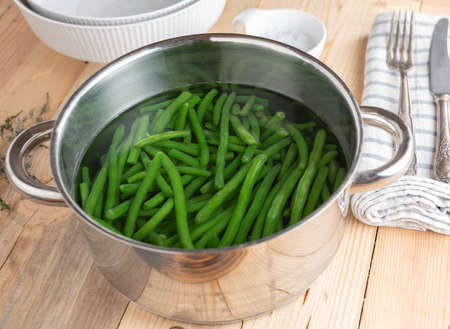 Cooking pot with raw green beans and water. Preparation and cooking of green princess beans.の写真素材