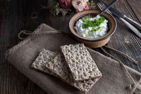 Diabetic or diabetes food with whole grain crispbread, cottage cheese and herbs. Served on rustic and dark wooden table background. Ready to eatの写真素材