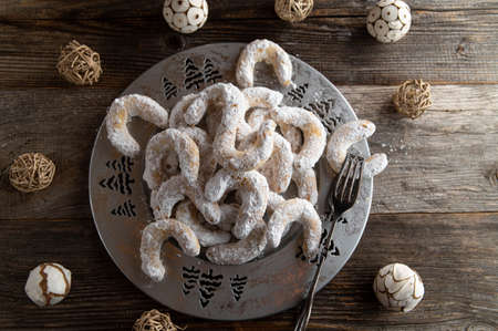 Traditional german christmas cookies called vanilla croissants. Served on a silver plate with decoration on dark wooden table background. Overhead view with copy spaceの写真素材