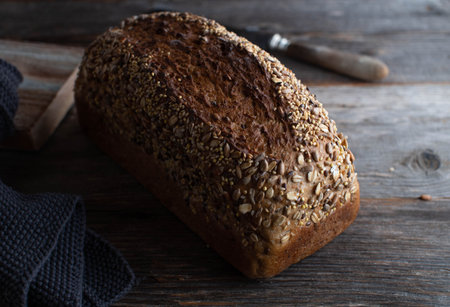 Loaf of whole wheat bread with seeds on a table. Delicious and healthy bread traditional from a...