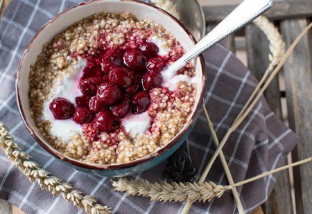 Breakfast cereal porridge with oats, amaranth, quinoa, yogurt and cooked cherriesの写真素材
