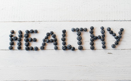 Blueberries on white background with the word "healthy". Closeup from above with copy spaceの写真素材