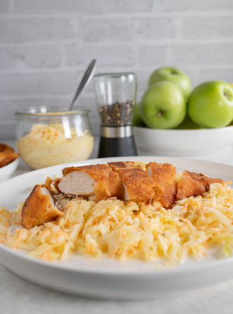 Breaded chicken breast with coleslaw on a plateの写真素材