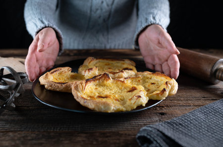 Woman in a wool sweater is serving a platter with pastryの写真素材