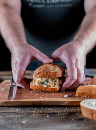 Man is grabbing a sandwich with tuna saladの写真素材