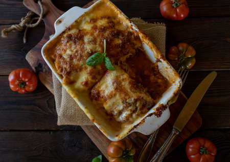 Lasagna with bolognese sauce and bechamel sauce with mozzarella cheese topping on rustic and wooden table from aboveの写真素材