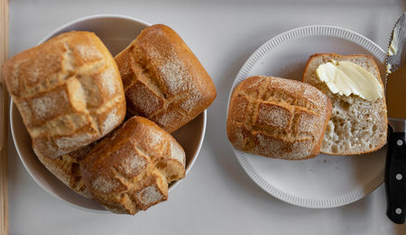 Sliced bun with butter and knife