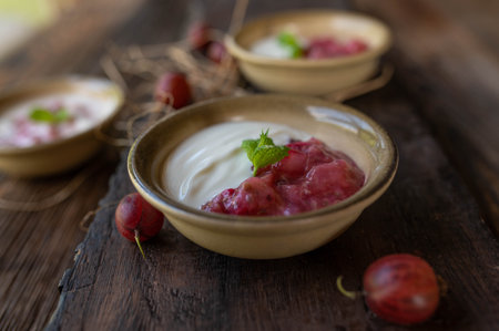 Gooseberry yogurt in a bowl on a rustic wooden backgroundの写真素材