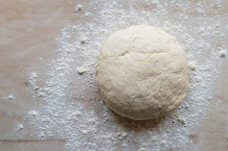 Raw yeast dough and flour on the table. top view