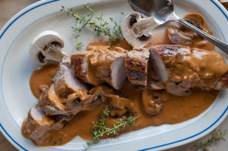 Pork fillet with mushroom cream sauce on a platterの写真素材