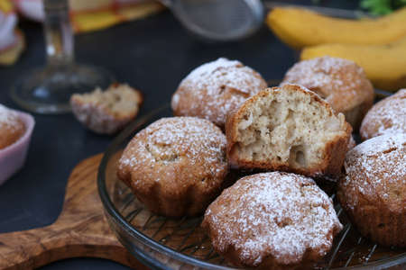 Muffins with bananas are located on plates against a dark backgroundの写真素材