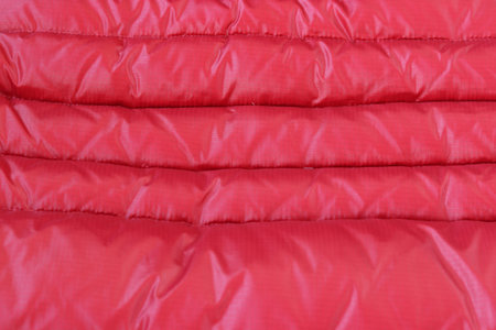 Texture concept - close up of crumpled red metallic fabric background
