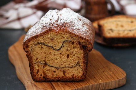 Cake with cocoa located on a dark background, On the cut of the cake strips of cocoa