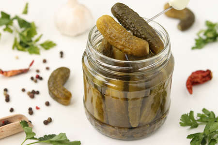 Homemade pickled cucumbers in a glass jar on a white background, top viewの写真素材