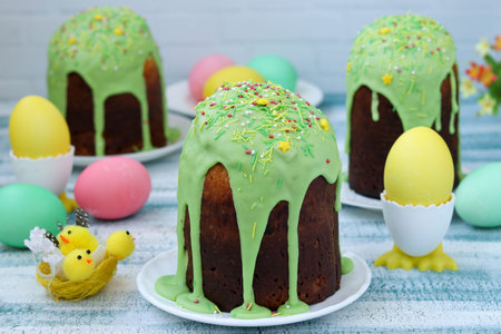 Spring still life of Easter cakes and painted eggs on blue background