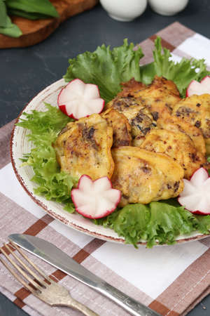 Chicken liver in batter is located on a plate on a dark background, top viewの写真素材