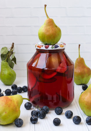 Compote of pears with blackthorn in a jar on a white background, Harvest for the winterの写真素材