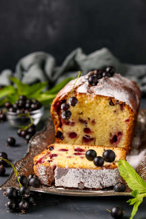 Black currant cupcake located on a tray against a dark background, vertical photo, close-upの写真素材