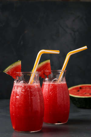 Smoothies with watermelon in jars on a dark background, vertical orientation, close-upの写真素材