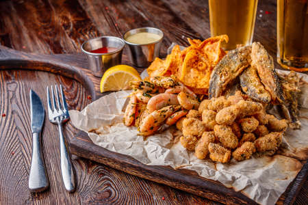 Set seafood: mussels, shrimps, small fried sea fish and crackers, food that is usually served with beer, horizontal orientation, close upの写真素材