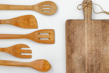 Wooden kitchen utensils on a white background, top view, horizontal orientation, closeup