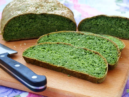 Homemade bread with nettles green, cut into slices and is located on a wooden board, horizontal orientationの写真素材