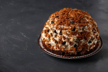 Pancho Cake with Sour Cream, Walnuts, Prunes and Chocolate on dark background, Close up, Copy space