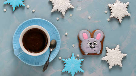 Cup of coffee and gingerbread cookies mouse and snowflakes on a light blue background, Top view, Closeup, horizontal orientationの写真素材