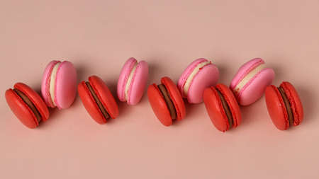 Tasty sweet cookies, red and pink macaroons on a pink background, Top view, horizontal orientation, Closeupの写真素材
