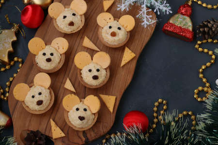 Tartlets Mice with cheese fo the New Year 2020 on wooden board on dark background, horizontal orientationの写真素材