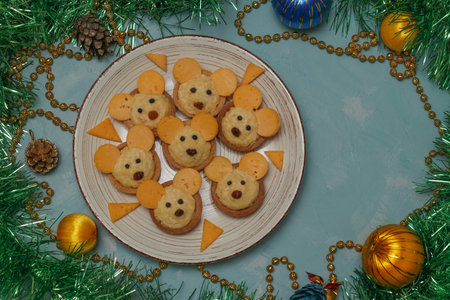 Tartlets Mice with cheese fo the New Year 2020 on a plate on light blue background, horizontal...