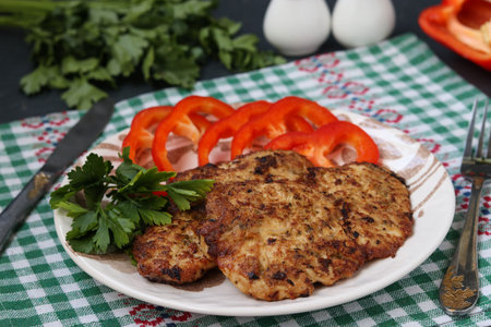 Turkey chops and sweet pepper on a plate against a dark background, Closeup, Horizontal orientation