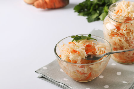 Fermented food, Homemade Sauerkraut with carrots in a bowl and jar on white background, Closeup