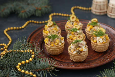 Tartlets with tuna, corn and eggs on a plate on dark backgroundの写真素材